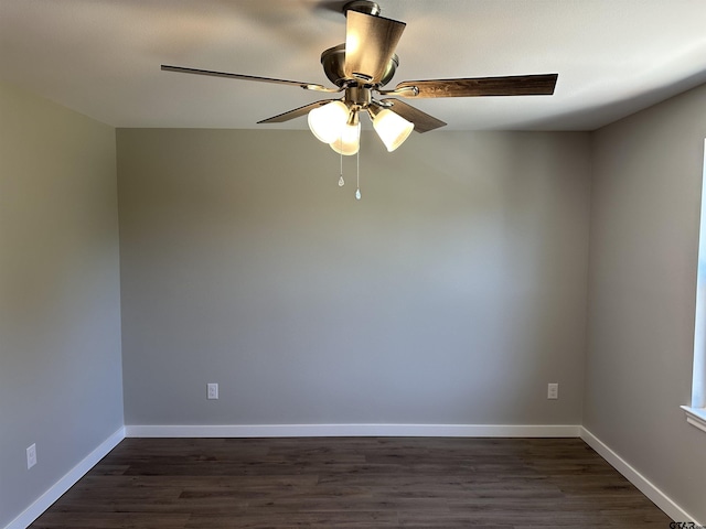 empty room with baseboards, a ceiling fan, and dark wood-type flooring