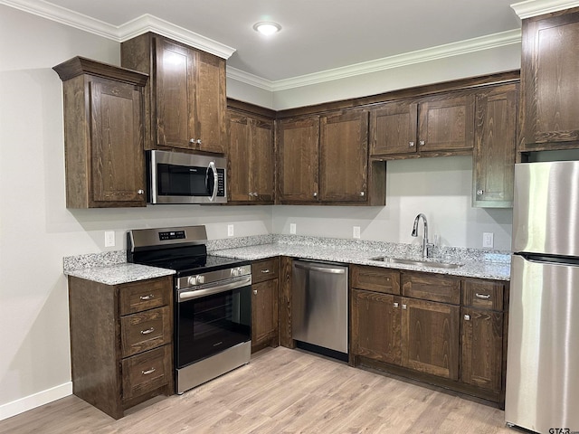 kitchen with dark brown cabinetry, a sink, and stainless steel appliances