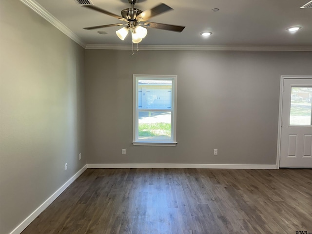 spare room featuring baseboards, ornamental molding, dark wood-style flooring, and plenty of natural light