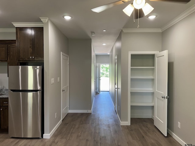 hallway featuring baseboards, recessed lighting, wood finished floors, and crown molding