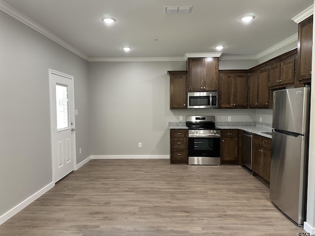 kitchen featuring appliances with stainless steel finishes, dark brown cabinets, baseboards, visible vents, and crown molding
