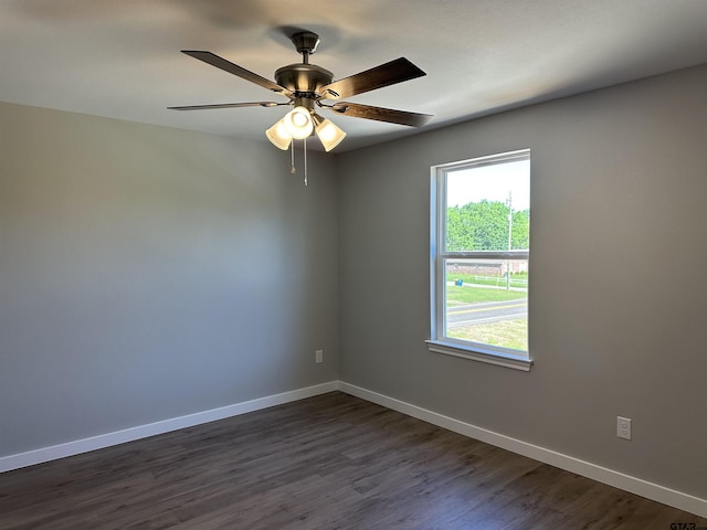 empty room featuring dark wood-style floors, baseboards, and a ceiling fan