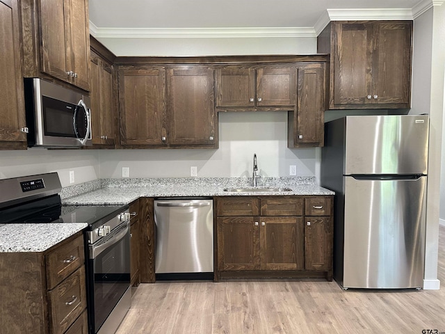 kitchen with ornamental molding, dark brown cabinetry, a sink, and appliances with stainless steel finishes