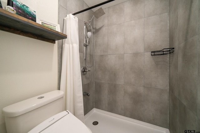 bathroom featuring a shower with shower curtain and toilet