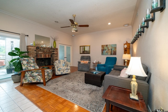 living room with light parquet floors, crown molding, a brick fireplace, ceiling fan, and a textured ceiling