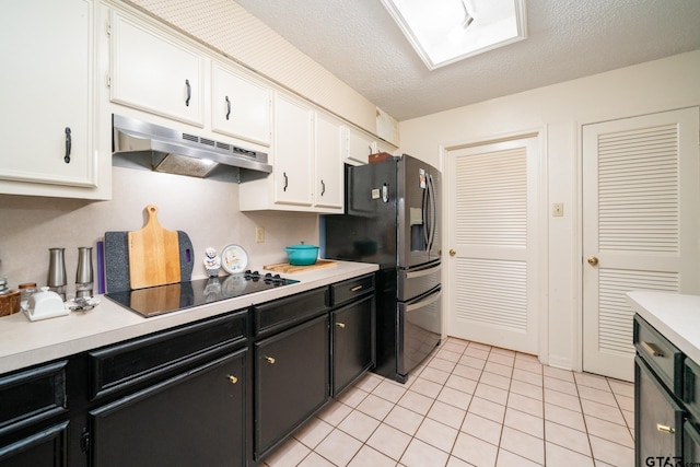 kitchen with stainless steel refrigerator with ice dispenser, a textured ceiling, black electric cooktop, and white cabinetry