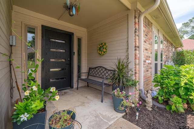 view of exterior entry featuring covered porch