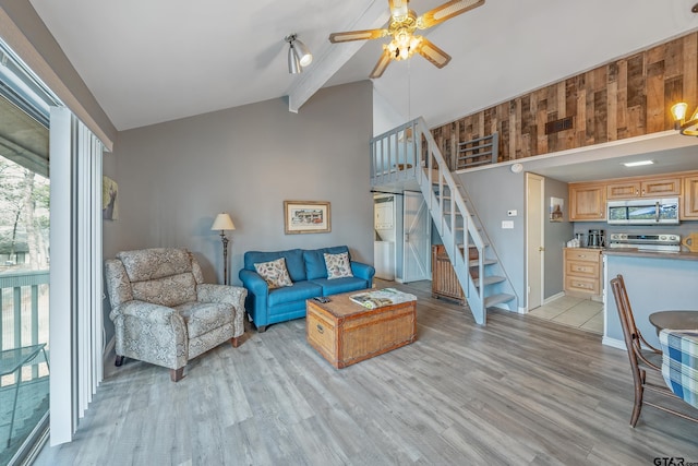 living room featuring ceiling fan, light hardwood / wood-style floors, and lofted ceiling with beams