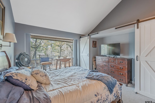 bedroom featuring lofted ceiling, a barn door, and carpet floors