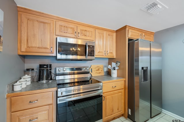 kitchen with light tile patterned flooring and stainless steel appliances