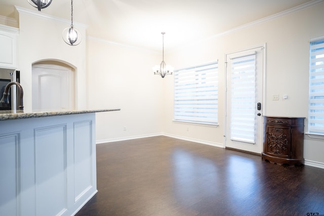 kitchen with hanging light fixtures, white cabinets, and a healthy amount of sunlight