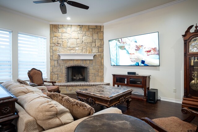 living room with dark hardwood / wood-style floors, ceiling fan, a stone fireplace, and ornamental molding