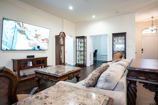 living room featuring dark wood-type flooring, plenty of natural light, crown molding, and a notable chandelier