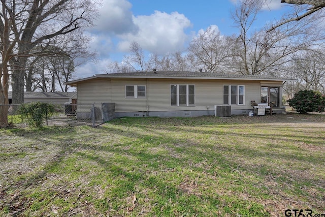 rear view of property featuring central AC unit and a yard