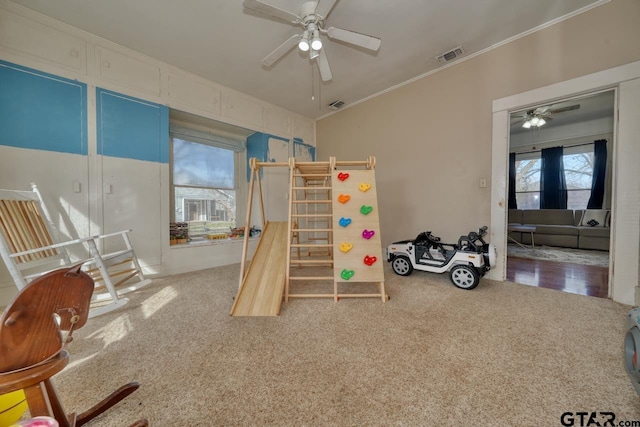 playroom featuring ceiling fan, ornamental molding, and carpet