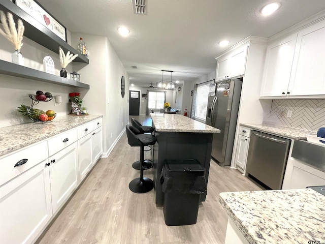 kitchen featuring white cabinetry, visible vents, appliances with stainless steel finishes, and open shelves