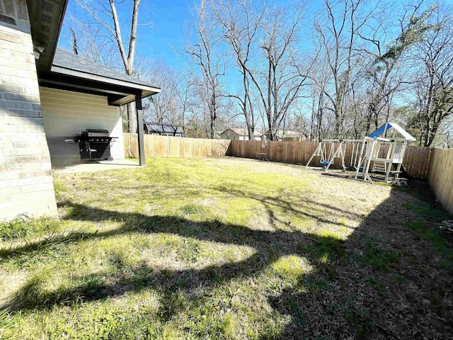 view of yard with a fenced backyard and a playground