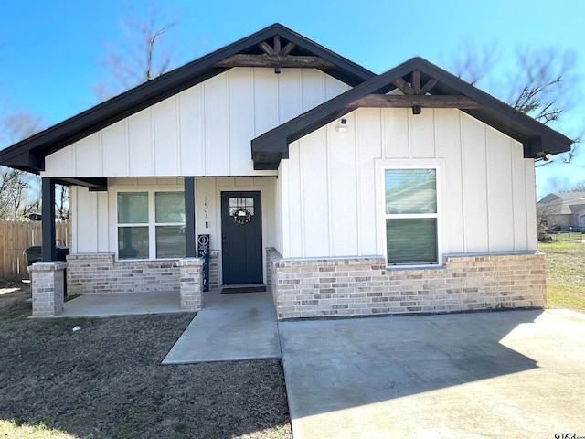 view of front of property with stone siding, a porch, and board and batten siding