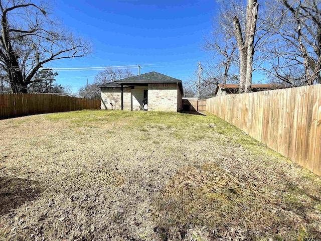 view of yard with a fenced backyard and an outdoor structure