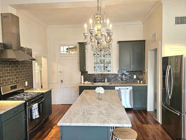 301 W Larissa, Jacksonville, TX 75766 - kitchen with stainless steel appliances, wall chimney exhaust hood, a sink, dark wood-style flooring, and a chandelier