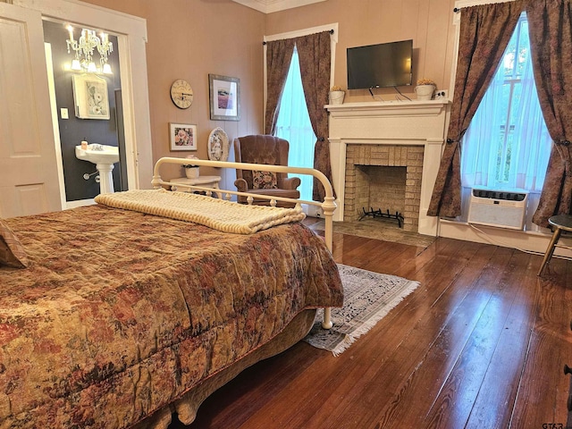 301 W Larissa, Jacksonville, TX 75766 - bedroom with hardwood / wood-style flooring, multiple windows, a brick fireplace, and cooling unit
