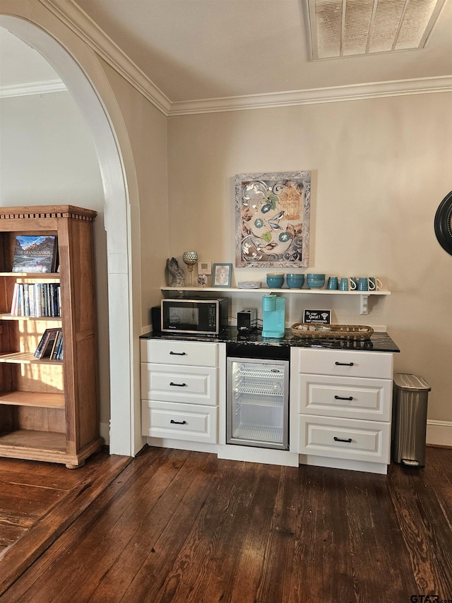 301 W Larissa, Jacksonville, TX 75766 - bar with beverage cooler, dark wood-type flooring, arched walkways, black microwave, and crown molding