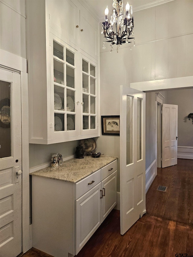 301 W Larissa, Jacksonville, TX 75766 - kitchen featuring dark wood finished floors, glass insert cabinets, white cabinets, a chandelier, and ornamental molding