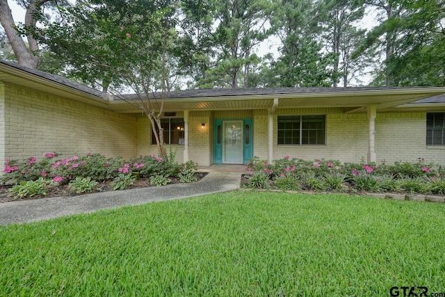 view of exterior entry with a yard