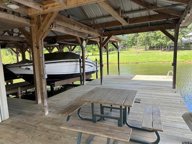 view of dock with a lawn, a water view, and boat lift