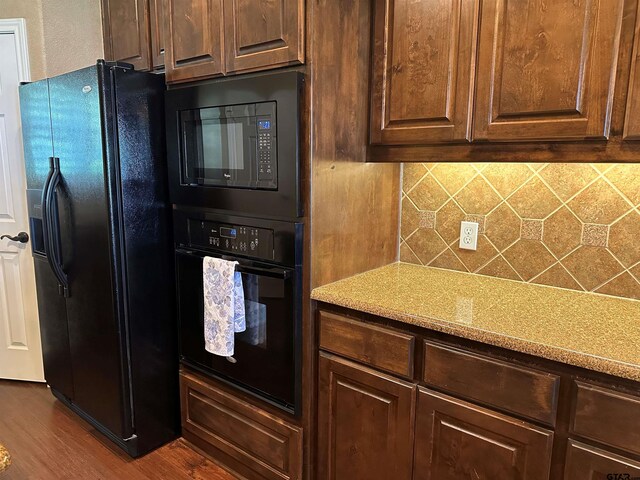 kitchen featuring dark brown cabinetry, light countertops, backsplash, dark wood-style floors, and black appliances