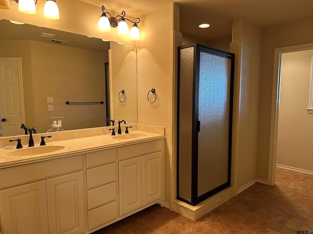 full bathroom featuring double vanity, visible vents, a shower stall, and a sink