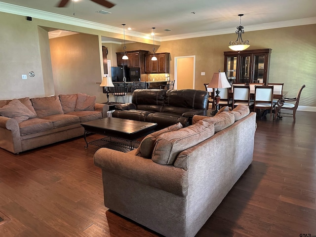 living room with crown molding, ceiling fan, baseboards, and dark wood-type flooring