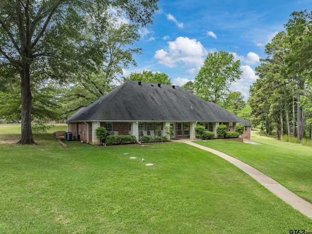 view of front of home with brick siding, a front lawn, and french doors