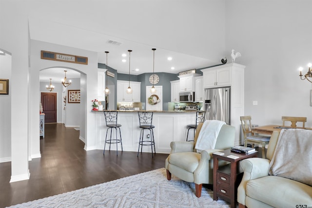 living room featuring an inviting chandelier and dark hardwood / wood-style flooring