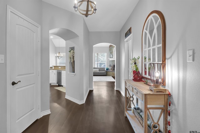 foyer entrance with an inviting chandelier and dark hardwood / wood-style flooring