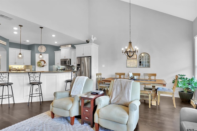 living room featuring lofted ceiling, dark wood-type flooring, and a notable chandelier