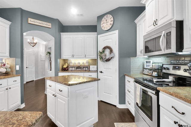 kitchen with stainless steel appliances, white cabinetry, and tasteful backsplash