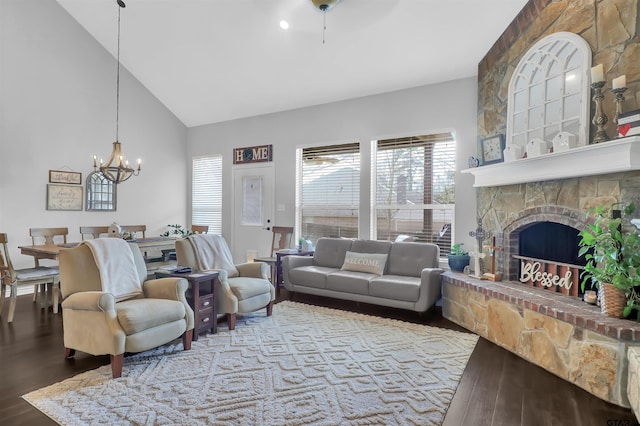 living room featuring a fireplace, wood-type flooring, high vaulted ceiling, and an inviting chandelier