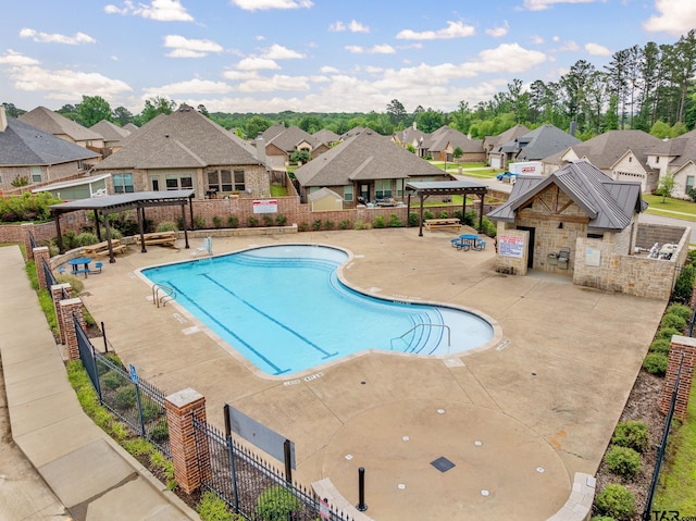 pool featuring a pergola, fence, a residential view, and a patio area