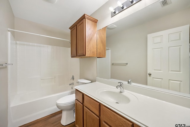 full bath featuring shower / tub combination, vanity, toilet, wood finished floors, and visible vents
