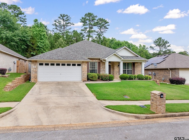 view of front facade with concrete driveway, an attached garage, a front yard, and brick siding