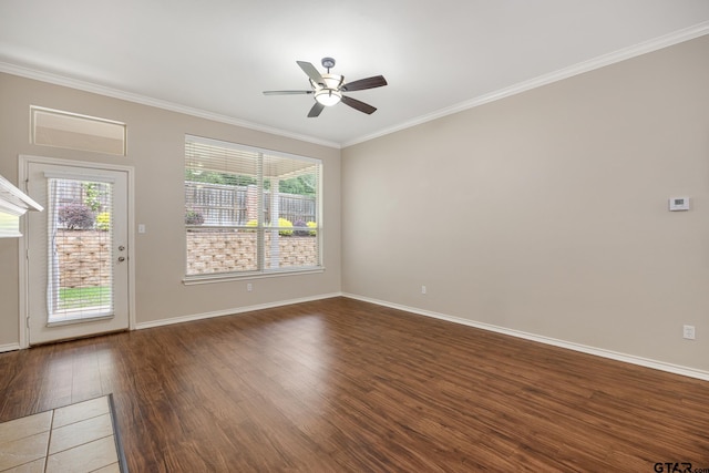 empty room with plenty of natural light, ornamental molding, a ceiling fan, and wood finished floors
