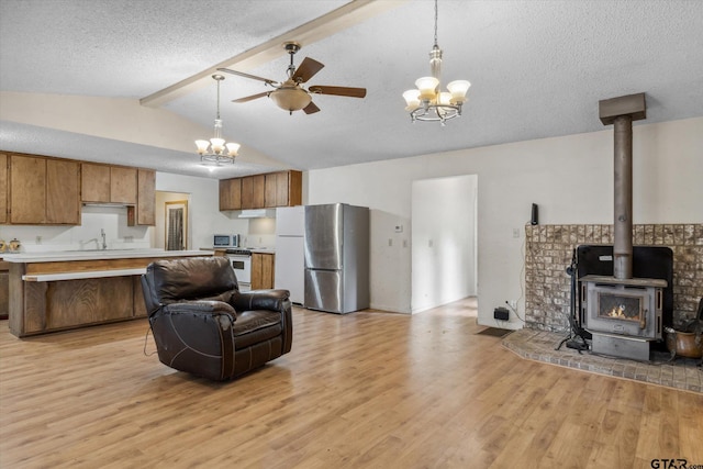 13386 Fm 858, Ben Wheeler, TX 75754 - kitchen with open floor plan, stainless steel appliances, brown cabinets, light countertops, and a textured ceiling