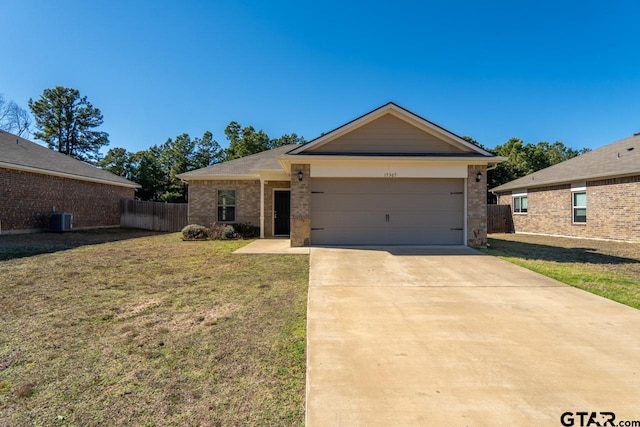 single story home featuring cooling unit, a garage, and a front yard