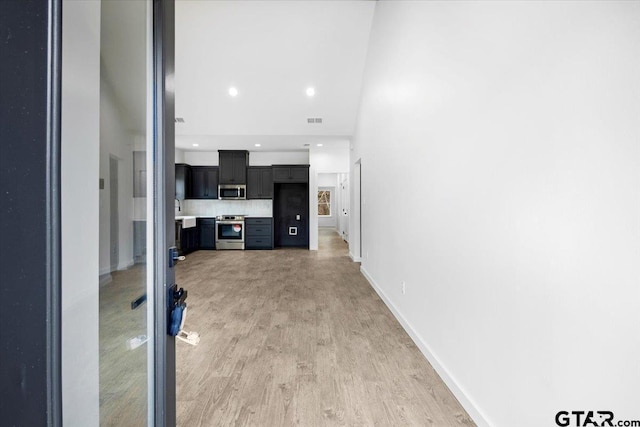 unfurnished living room with recessed lighting, visible vents, light wood-style flooring, and baseboards