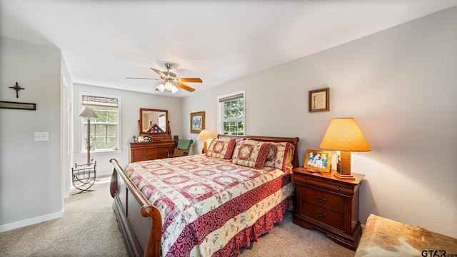 carpeted bedroom featuring ceiling fan and multiple windows