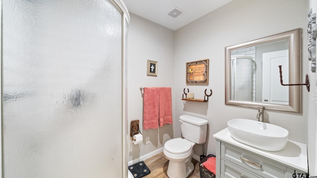 bathroom featuring walk in shower, vanity, toilet, and hardwood / wood-style flooring