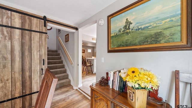 staircase featuring a barn door and hardwood / wood-style floors