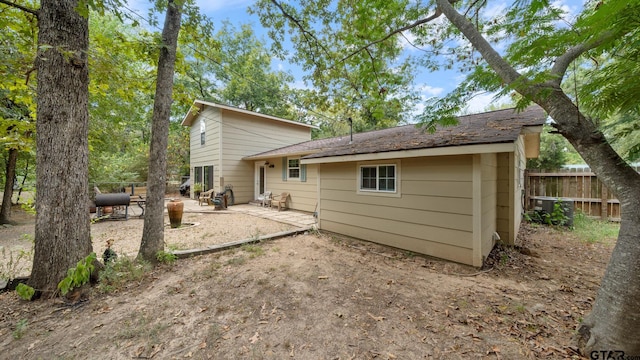 back of property with central AC and a patio area