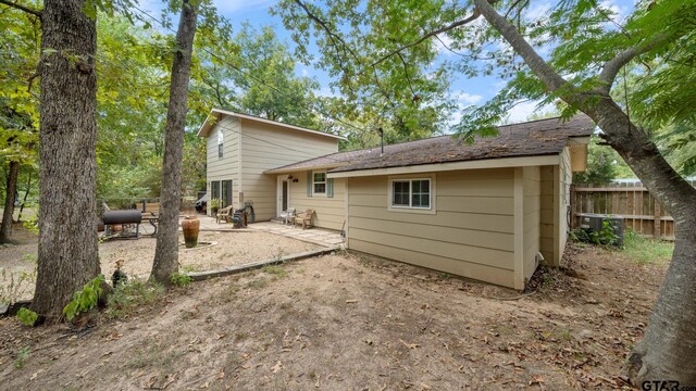 back of property with central AC and a patio area